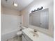 This bathroom features white fixtures, a tub, and a vanity with lots of lights at 7621 Orchard Village Dr, Indianapolis, IN 46217