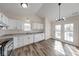 Modern kitchen boasts white cabinets, stainless steel appliances, and wood-look flooring at 7621 Orchard Village Dr, Indianapolis, IN 46217