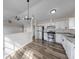 Open kitchen with stainless steel appliances, granite counters, and wood-look floors at 7621 Orchard Village Dr, Indianapolis, IN 46217