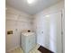 Functional laundry room with vintage washer, overhead shelving and a door at 7621 Orchard Village Dr, Indianapolis, IN 46217