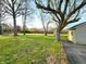 Spacious backyard featuring green grass, mature trees, storage shed, and a partial view of the house at 8143 Filly Ln, Plainfield, IN 46168