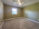 A neutral bedroom with carpet, a ceiling fan, and a window for natural light at 8143 Filly Ln, Plainfield, IN 46168