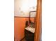 Cozy powder room features granite counters, a stylish mirror, and warm orange wall at 8513 Shelbyville Rd, Indianapolis, IN 46259