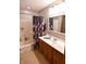 Bathroom featuring tub with shower, floral curtains, vanity with sink, and framed mirror at 8513 Shelbyville Rd, Indianapolis, IN 46259