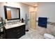 Modern bathroom featuring tiled floor, dark vanity with sink, and a glass shower stall at 8513 Shelbyville Rd, Indianapolis, IN 46259