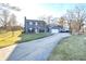 Charming blue home featuring an attached garage, long driveway, and ample yard space at 8513 Shelbyville Rd, Indianapolis, IN 46259
