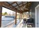 A covered patio with wooden posts, ceiling fans, and outdoor grill and access to backyard at 8513 Shelbyville Rd, Indianapolis, IN 46259
