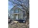 Two-story home with pale green siding, white trim, covered front porch, and construction materials in yard at 922 N Oakland Ave, Indianapolis, IN 46201