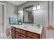 Bathroom vanity featuring a marble countertop, wooden cabinets, framed mirror, and decorative lighting at 9615 N County Road 150 E Rd, Pittsboro, IN 46167