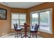Breakfast nook with bar table, two chairs, and large bright windows overlooking backyard patio at 9615 N County Road 150 E Rd, Pittsboro, IN 46167