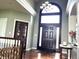 Grand foyer with soaring ceilings, dark wood flooring, and a beautiful arched doorway with glass detailing at 9615 N County Road 150 E Rd, Pittsboro, IN 46167