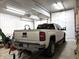 Well-lit garage showcasing a white GMC Sierra truck parked inside at 9615 N County Road 150 E Rd, Pittsboro, IN 46167
