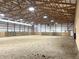 Large indoor riding arena featuring a well-lit, spacious layout and a sand floor for equestrian training at 9615 N County Road 150 E Rd, Pittsboro, IN 46167