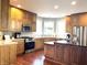 A spacious kitchen is presented with wood cabinets, stainless steel appliances, and a center island with black countertop at 9615 N County Road 150 E Rd, Pittsboro, IN 46167
