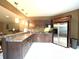Basement kitchenette with brown cabinetry, stainless steel appliances, and granite countertops at 9615 N County Road 150 E Rd, Pittsboro, IN 46167