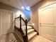 Carpeted stairway with wooden railing and white spindles between two doorways with a light fixture at 9615 N County Road 150 E Rd, Pittsboro, IN 46167