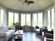 A sunroom with multiple windows, indoor plants, and a sitting area with a ceiling fan at 9615 N County Road 150 E Rd, Pittsboro, IN 46167
