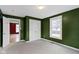Green-painted bedroom featuring a window, gray carpet, and a closet, offering a cozy and bright space at 1019 Lennox St, Anderson, IN 46012