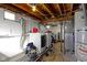 Functional laundry area in the basement with washer, dryer, and water heater at 1019 Lennox St, Anderson, IN 46012