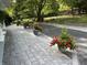 Long driveway lined with red geranium planters and lush green trees at 1020 W Riverview Dr, Anderson, IN 46011