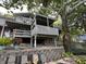 View of the home's multi-level deck and landscaping, shaded by a large tree at 1020 W Riverview Dr, Anderson, IN 46011