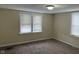 This bedroom features carpet, neutral walls, and two large windows for plenty of light at 1126 N Mitthoeffer Rd, Indianapolis, IN 46229