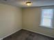 This bedroom features neutral walls, a window with blinds, and carpet flooring at 1126 N Mitthoeffer Rd, Indianapolis, IN 46229