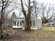 A modest home with light siding and a cozy sunroom, surrounded by mature trees in a quiet setting at 1126 N Mitthoeffer Rd, Indianapolis, IN 46229