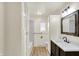Bright bathroom featuring a dark vanity, a built in storage cabinet, and a tiled shower and bathtub combo at 1157 Evans Ave, Noblesville, IN 46060
