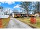A charming brick home, framed by a large tree and a driveway, under a partly cloudy sky at 1157 Evans Ave, Noblesville, IN 46060