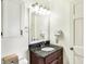 Cozy bathroom with a granite vanity top, decorative lighting fixture, and white cabinets for added storage at 12601 Slippery Rock Rd, Indianapolis, IN 46236