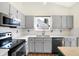 Updated kitchen featuring stainless steel appliances, white subway tile, and light gray cabinetry at 12601 Slippery Rock Rd, Indianapolis, IN 46236
