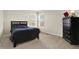 A cozy bedroom features a bed and dresser, complemented by natural light streaming through the window at 13788 Four Seasons Way, Carmel, IN 46074