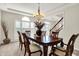 Formal dining room featuring a wood table, chandelier, and large windows for ample natural light at 13788 Four Seasons Way, Carmel, IN 46074