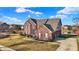Charming two-story brick home featuring a three-car garage and well-maintained front yard at 13788 Four Seasons Way, Carmel, IN 46074