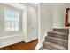 Welcoming hallway boasts a built-in bench, hardwood floors, and stair access to the upper level at 13788 Four Seasons Way, Carmel, IN 46074
