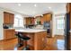 Kitchen featuring a central island with bar seating, mosaic tile backsplash, and stainless steel appliances at 13788 Four Seasons Way, Carmel, IN 46074
