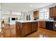 Bright kitchen features a large island, hardwood floors, stainless appliances, and access to a living room at 13788 Four Seasons Way, Carmel, IN 46074