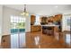 Open kitchen featuring a central island with bar seating, hardwood floors, and natural light at 13788 Four Seasons Way, Carmel, IN 46074