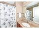 Bathroom with a shower/tub combination with a floral shower curtain, granite countertop, and a decorative mirror at 14034 Wicklow Ln, Fishers, IN 46040