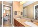 Bathroom featuring dual sinks with granite countertops and a decorative mirror, leading into the bedroom at 14034 Wicklow Ln, Fishers, IN 46040