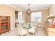 Elegant dining room with a glass table, upholstered chairs, decorative lighting, and a view into the foyer at 14034 Wicklow Ln, Fishers, IN 46040