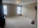 A empty room with neutral tones, carpet floors, windows for natural light, and ample space at 14309 Shooting Star Dr, Noblesville, IN 46060