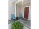 Inviting front porch with neutral siding, red door, and seating, creating a welcoming entrance at 14309 Shooting Star Dr, Noblesville, IN 46060