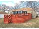 Charming backyard with a large wood deck and furniture; view of stone home and yard at 1739 Forest Dr, Indianapolis, IN 46227