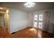 Bright dining room featuring hardwood floors, elegant lighting, and charming french doors with floral curtains at 1739 Forest Dr, Indianapolis, IN 46227
