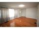 Sunlit living room featuring gleaming hardwood floors and large windows with decorative curtains at 1739 Forest Dr, Indianapolis, IN 46227
