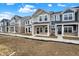 Newly built townhomes with varying colors and brick under a blue sky at 19499 Grassy Branch Rd, Westfield, IN 46074