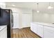 Open kitchen with stainless steel refrigerator, island with white countertops, and hardwood flooring at 19499 Grassy Branch Rd, Westfield, IN 46074
