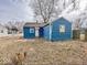 Exterior of the blue home with a white door, a stump, and a fenced in yard at 2370 N Moreland Ave, Indianapolis, IN 46222